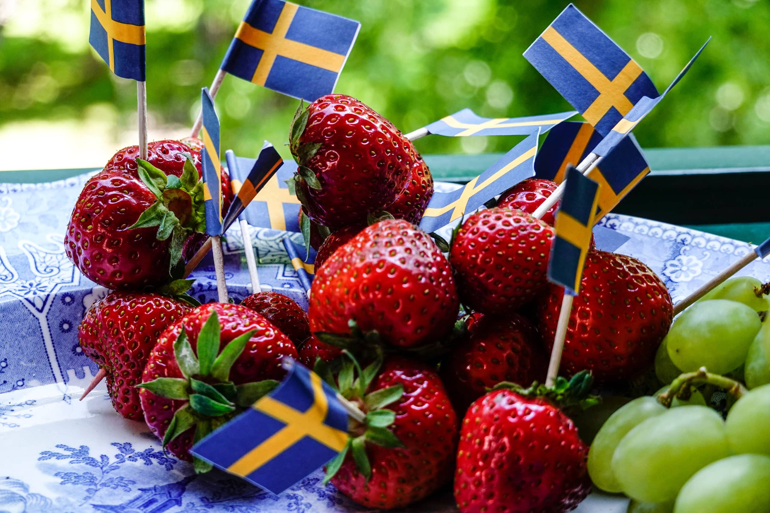 Jordgubbar och svenska flaggor på ett fat – klassisk midsommarmat i Stockholm